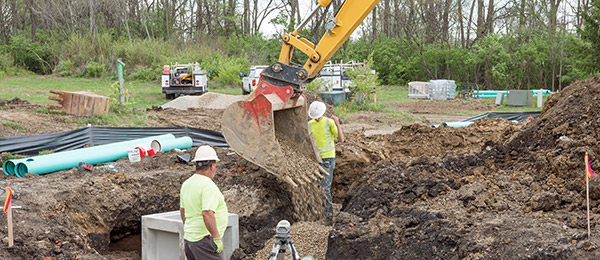 Workers backfill a drainage area Backfilling